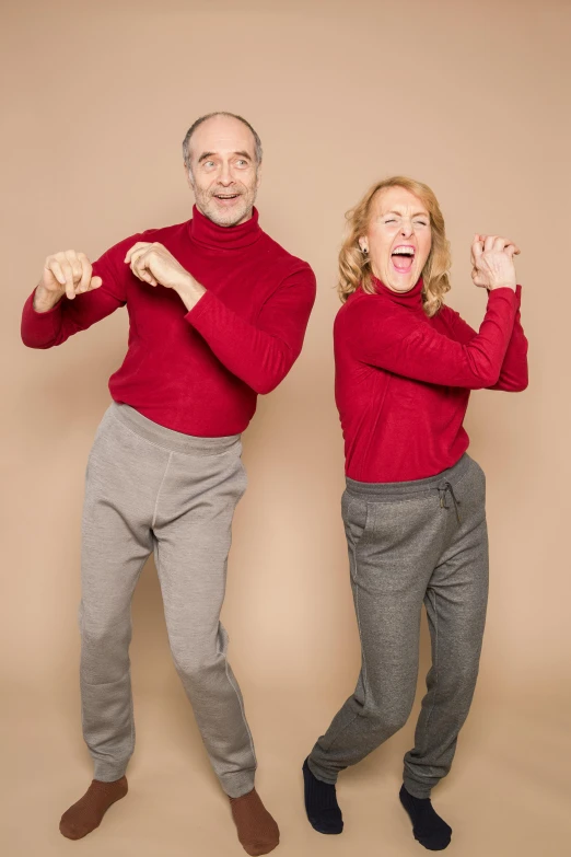 a couple of people standing next to each other, an album cover, inspired by Peter Maxwell Ewart, antipodeans, red sweater and gray pants, lois greenfield, doing a sassy pose, uncropped