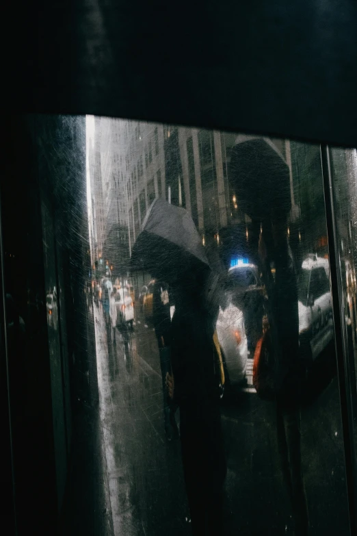 a person holding an umbrella in the rain, inspired by Gordon Parks, photorealism, reflection of phone in visor, color photograph, 1999 photograph, window ( city )