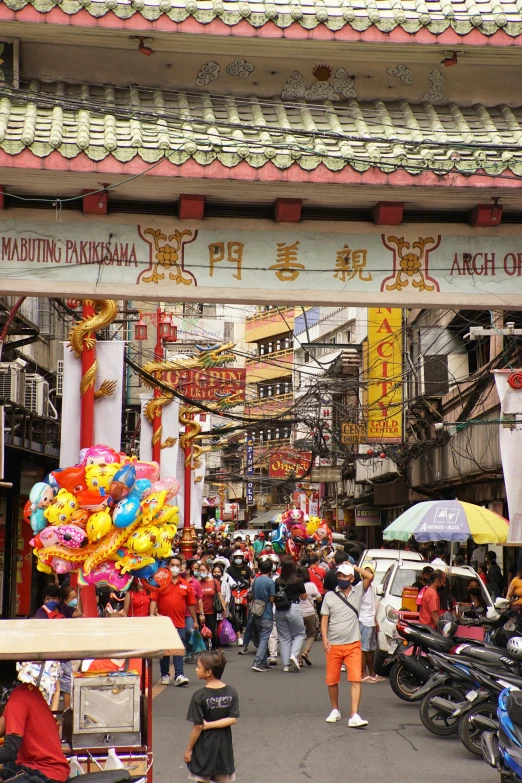 a group of people walking down a street, a photo, mingei, china town blade runner, decorations, philippines, multiple stories