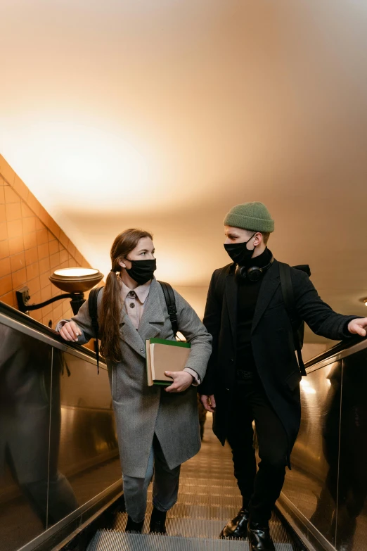 a man and a woman walking down an escalator, trending on pexels, renaissance, ski masks, in a hotel hallway, student, a green