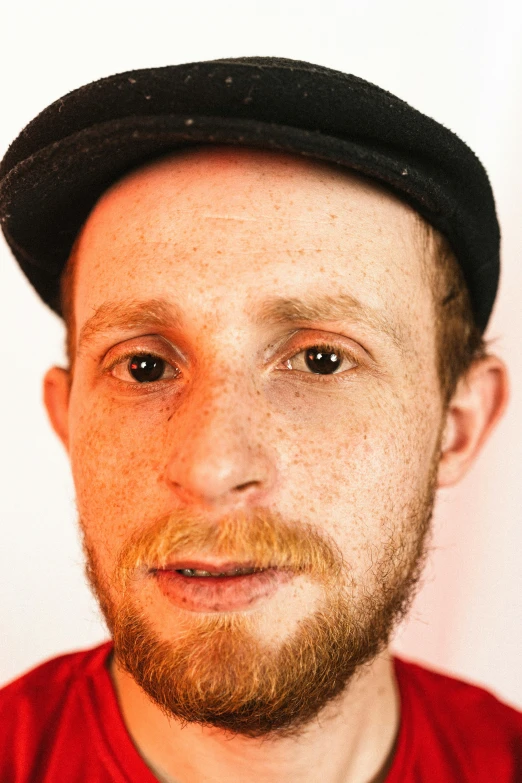 a close up of a person wearing a hat, by Jesse Richards, reddish beard, black eyes and large forehead, alex ries, catalog photo