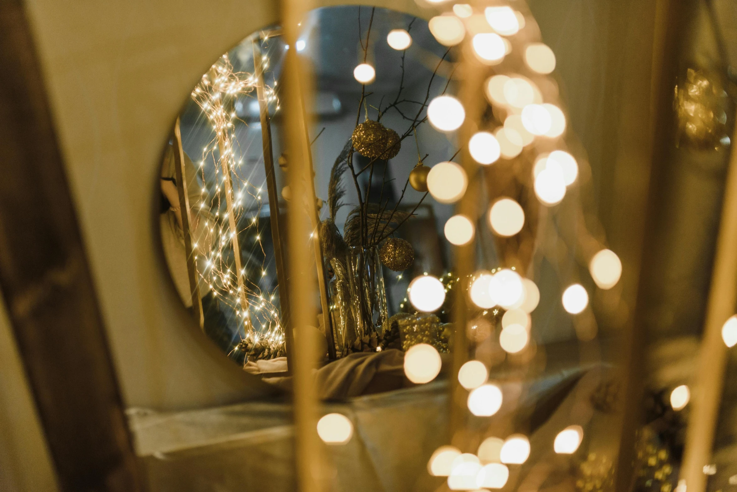 a mirror sitting on top of a table covered in christmas lights, by Adam Marczyński, pexels contest winner, light and space, two moons lighting, fan favorite, lights with bloom, golden dapple lighting