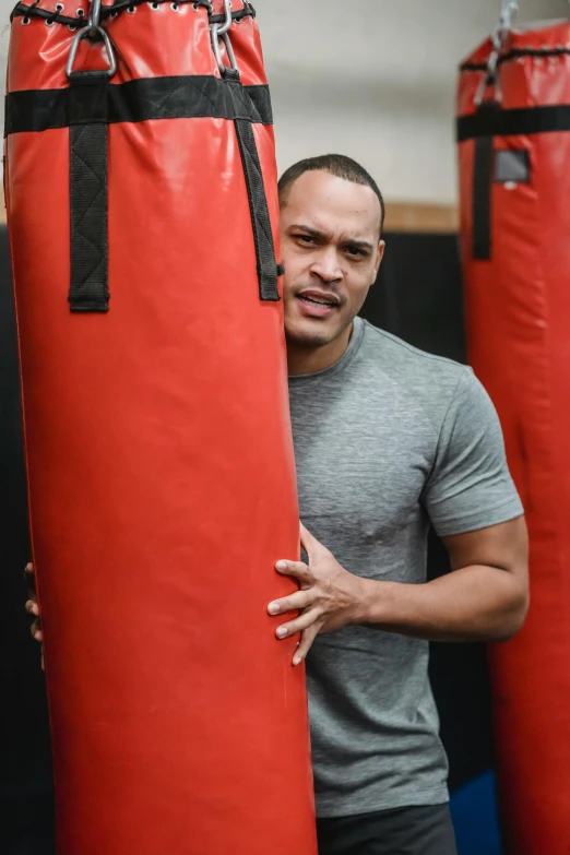a man standing in front of a punching bag, inspired by Gerald Kelly, happening, profile image, smooth in the background, profile picture, temuera morrison