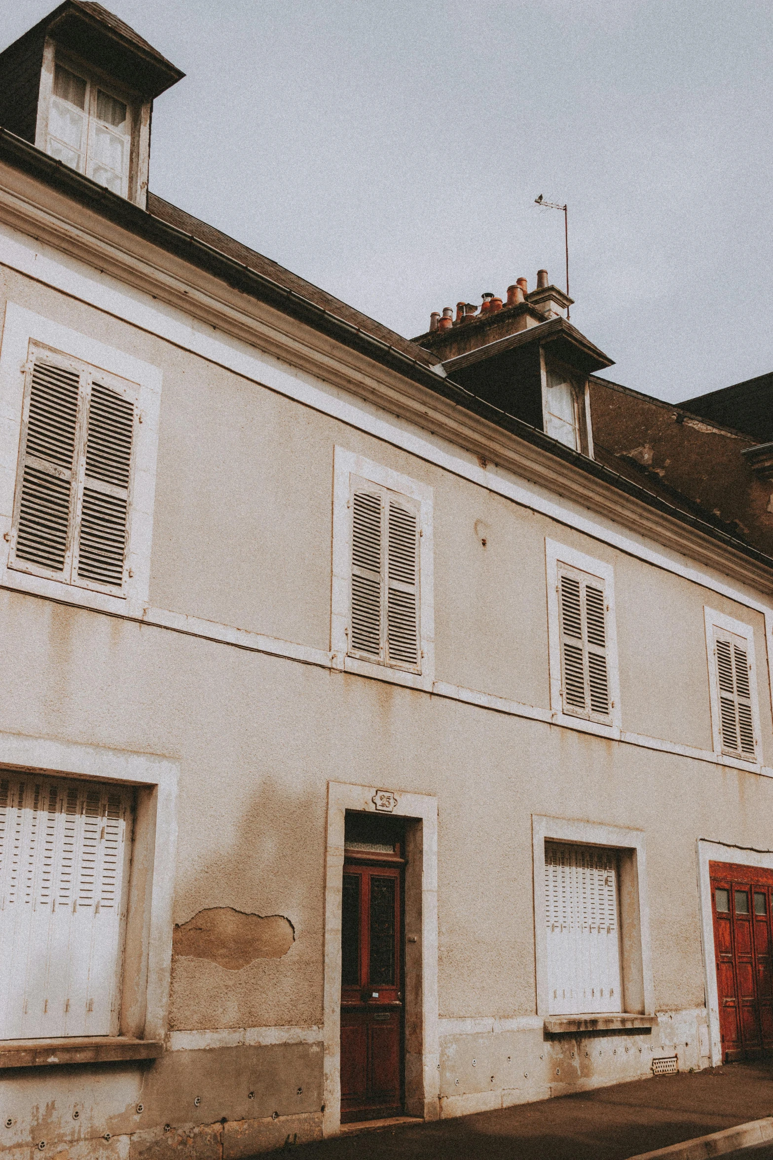 a red fire hydrant sitting on the side of a street, an album cover, inspired by Étienne Aubry, paris school, white houses, shutters, trending on vsco, 1 8 th century style