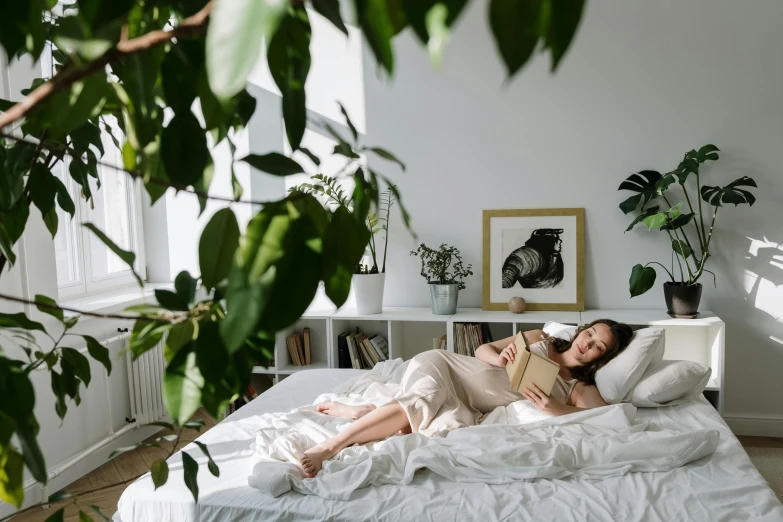 a couple of women laying on top of a bed, by Julia Pishtar, pexels contest winner, happening, romantic greenery, reading, wide full body, a single