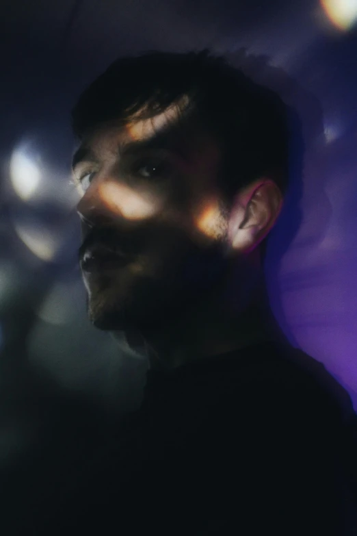 a man standing in front of a purple light, an album cover, pexels contest winner, synthetism, tom burke, glossy flecks of iridescence, spock, headshot profile picture