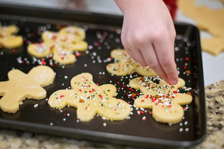 a person putting sprinkles on some cookies, holiday season, promo image, unbeatable quality, shiny surfaces