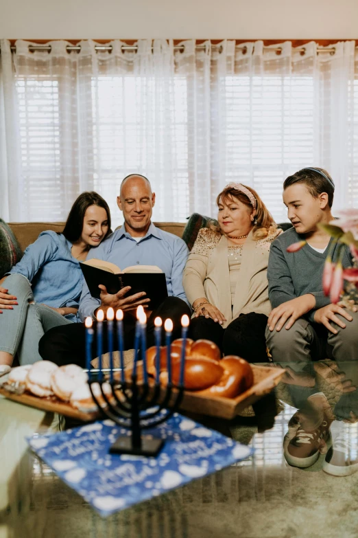a group of people sitting on a couch in a living room, candle lighting, hebrew, holiday vibe, fan favorite