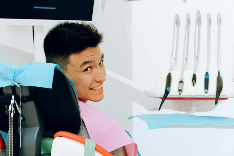 a man that is sitting in a chair, inspired by Tooth Wu, pexels contest winner, hurufiyya, uniform teeth, coloured photo, handsome chad chin, dentist