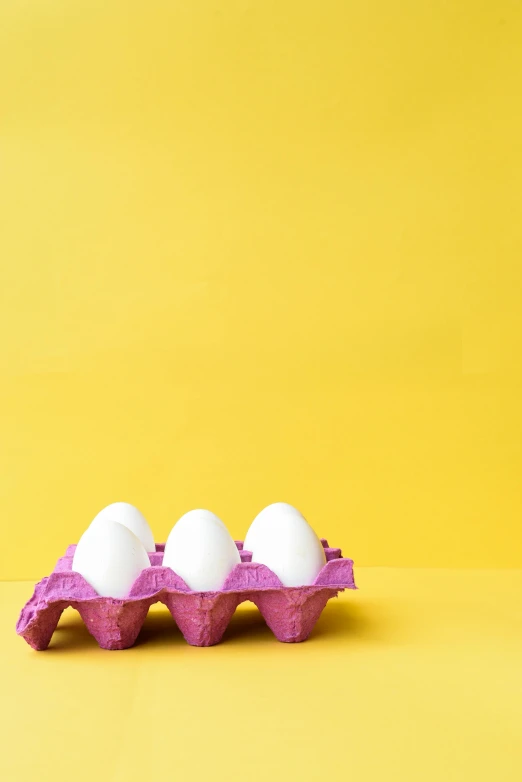 three eggs in a carton on a yellow background, by Winona Nelson, trending on unsplash, pop art, white and purple, cake, white male, 15081959 21121991 01012000 4k