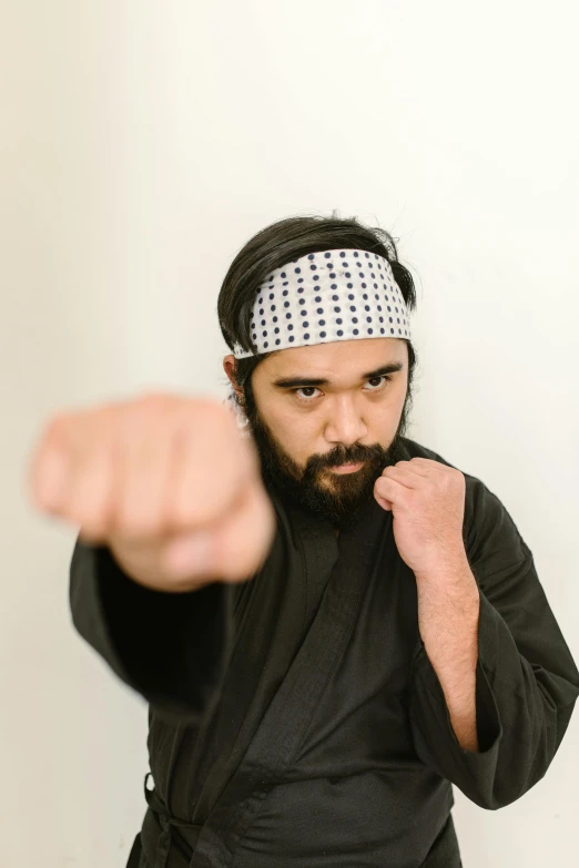 a man wearing a bandana pointing at the camera, inspired by Baiōken Eishun, hurufiyya, profile image, performance, alejandro, ninja jesus