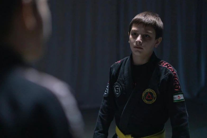 a young man in a black jacket and yellow belt, pexels contest winner, antipodeans, production still, bully maguire, aged 13, hasbulla magomedov