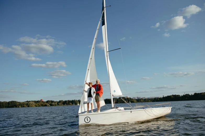 two people standing on a sailboat in the water, espoo, easy to use, beginner, unwind!