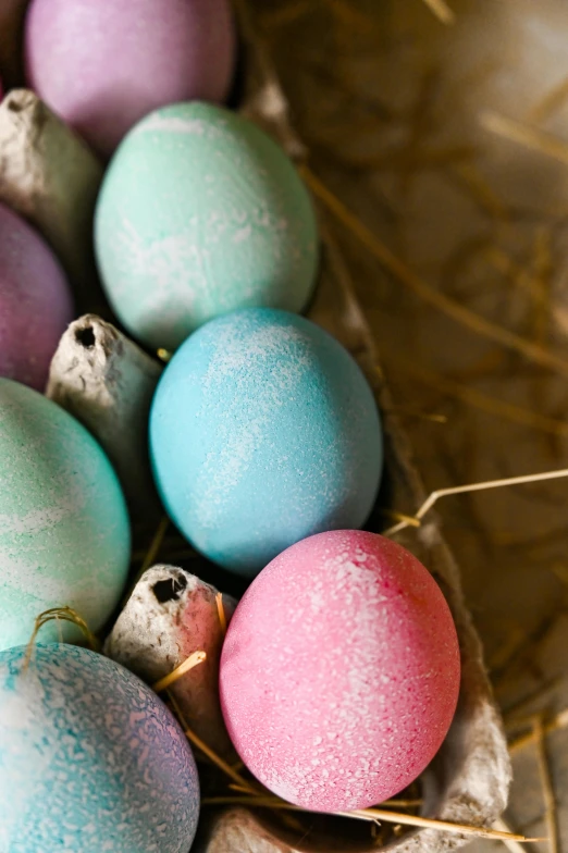 a basket filled with eggs sitting on top of a table, pink and blue and green mist, chalk, thumbnail, upclose