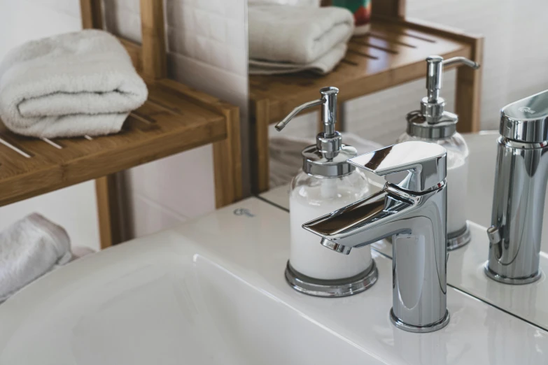 a bathroom sink with two chrome faucets and soap dispensers, inspired by Lewis Henry Meakin, unsplash, closeup - view, bath, picturesque, upscaled to high resolution