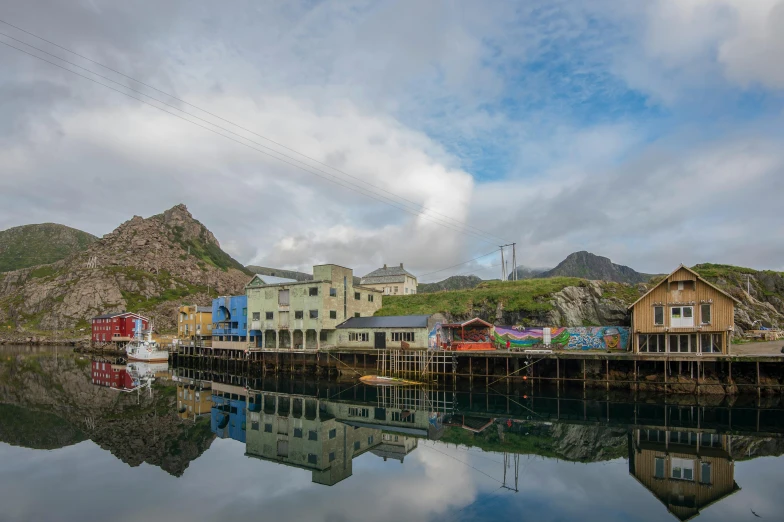 a group of houses sitting on top of a body of water, by Roar Kjernstad, pexels contest winner, plein air, bordalo, glassy reflections, viewed from the harbor, balaskas