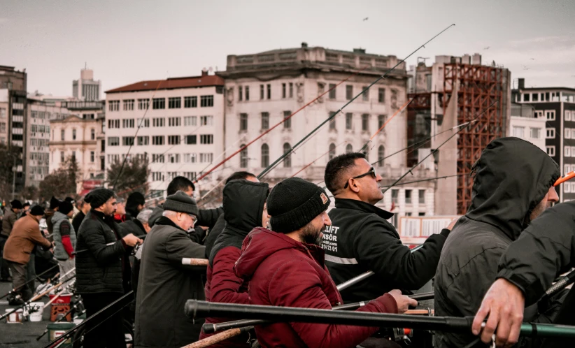 a group of people standing on top of a boat, by Kristian Zahrtmann, pexels contest winner, happening, fishing, view from the streets, wellington, audience in the background