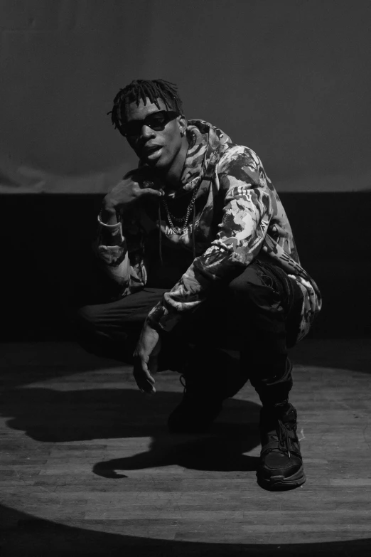 a man kneeling on top of a wooden floor, an album cover, by Maxwell Bates, unsplash, visual art, playboi carti portrait, only black and white, gold chains, julian ope