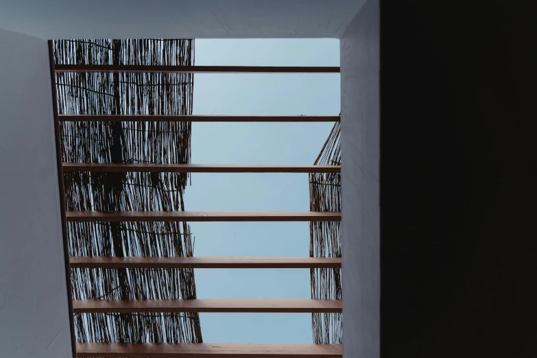 a staircase leading up to the top of a building, a digital rendering, inspired by Peter Zumthor, unsplash, thatched roofs, looking at the sky, mexico, seen through a window