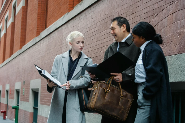 a couple of people standing next to a building, woman in business suit, varying ethnicities, holding a clipboard, look at the details