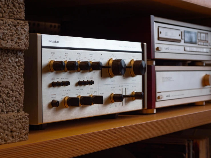 a stereo system sitting on top of a wooden shelf, by Yasushi Sugiyama, unsplash, realism, vintage transistors, gold and silver tones, 1980s photo, high quality product image”