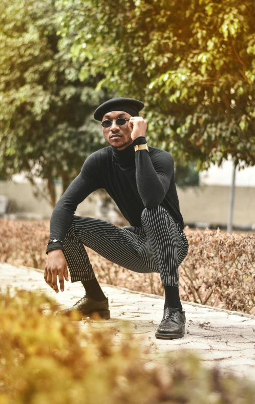 a man sitting on a sidewalk talking on a cell phone, inspired by Theo Constanté, trending on pexels, black stripes, beret and sunglasses, doing an elegant pose over you, wearing black tight clothing