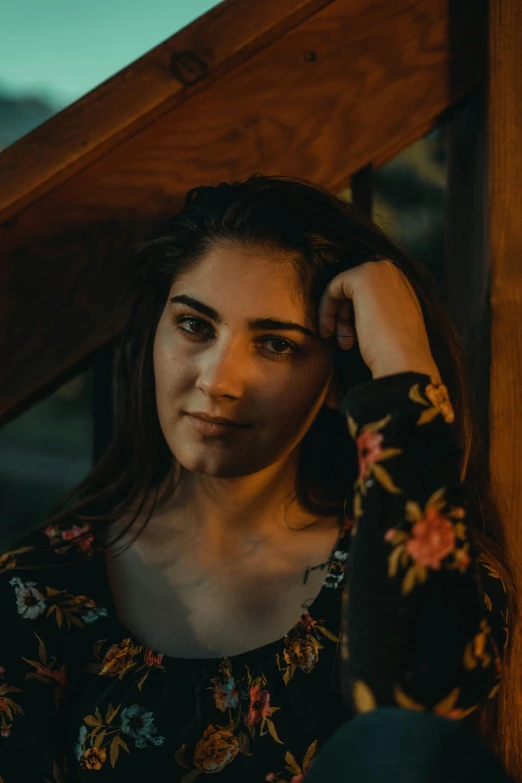 a woman sitting on top of a wooden staircase, inspired by Elsa Bleda, pexels contest winner, halfbody headshot, young middle eastern woman, low-light photograph, head shot