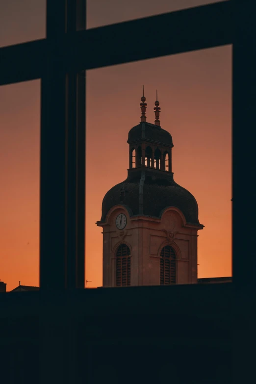 a clock tower is seen through a window, a picture, by Jan Tengnagel, unsplash contest winner, sunset glow around head, domes, low quality photo, black windows