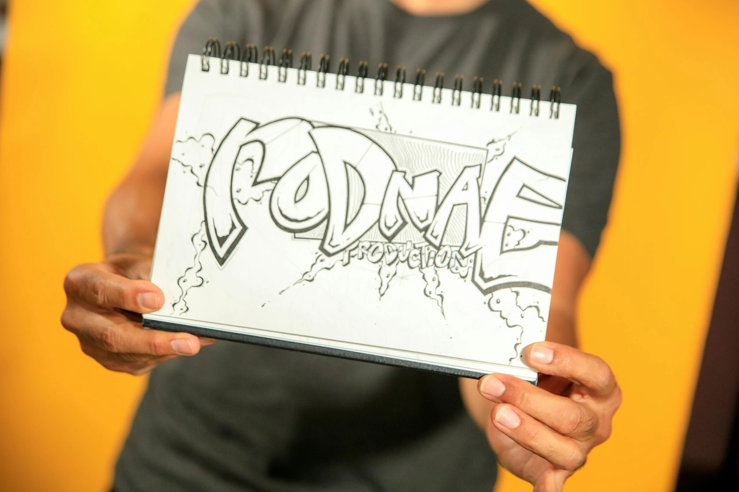 a person holding a notebook with a drawing on it, a drawing, inspired by Rodolphe Töpffer, graffiti, octane remder, style lettering, thumbnail, middle shot