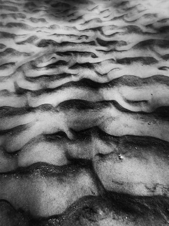 a black and white photo of sand on the beach, inspired by Edward Weston, psychedelic waves, wet collodion, shot with iphone 1 0, wrinkled skin