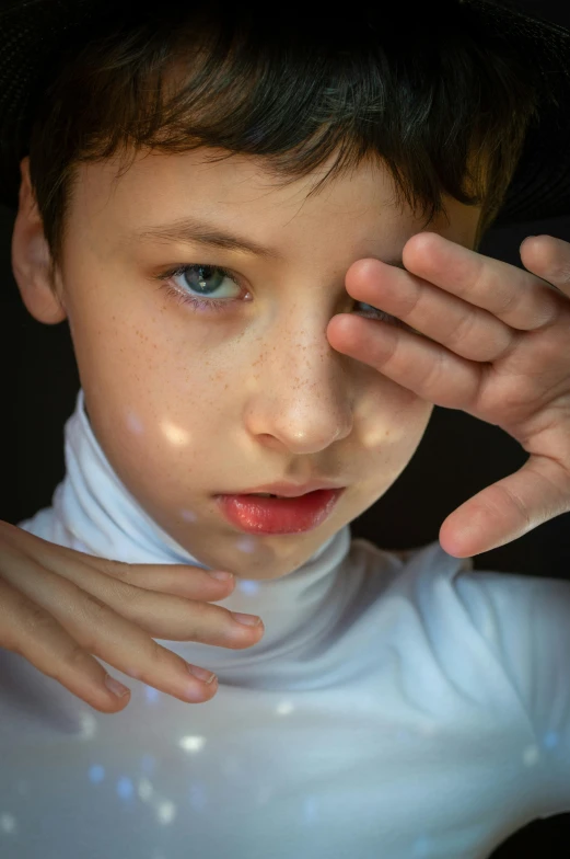 a close up of a child with a hat on, an album cover, by irakli nadar, hyperrealism, light emitting from fingertips, porcelain highlighted skin, portrait of 1 5 - year - old boy, transparent celestial light gels