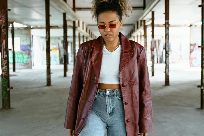 a woman wearing a red leather jacket and jeans, trending on pexels, visual art, aboriginal australian hipster, brown skinned, 90s photo, wearing trenchcoat