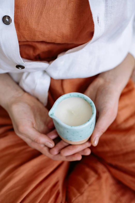 a woman holding a cup of milk in her hands, unsplash, renaissance, made of glowing wax and ceramic, sage, detailed product image, bedhead