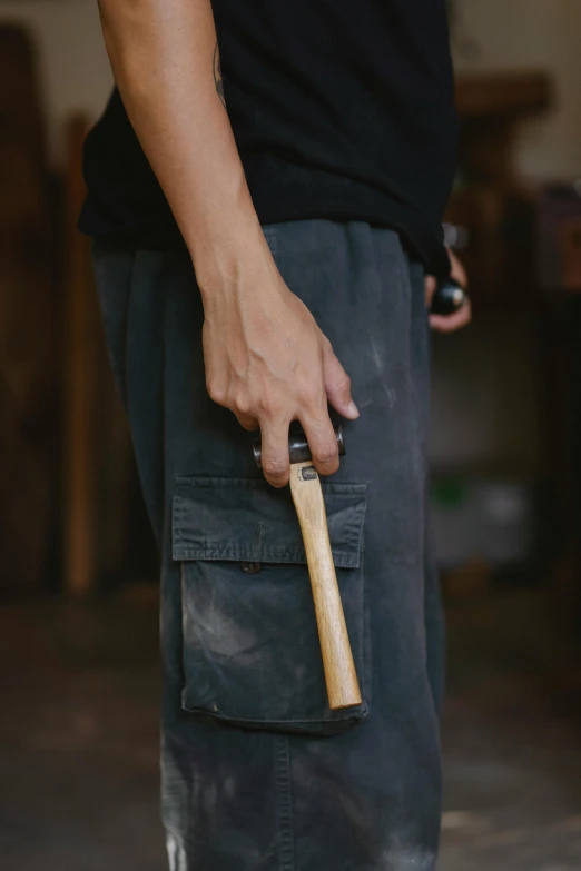 a man holding a hammer in his pocket, inspired by Inshō Dōmoto, unsplash, in a workshop, detailed product image, portrait shot, australian