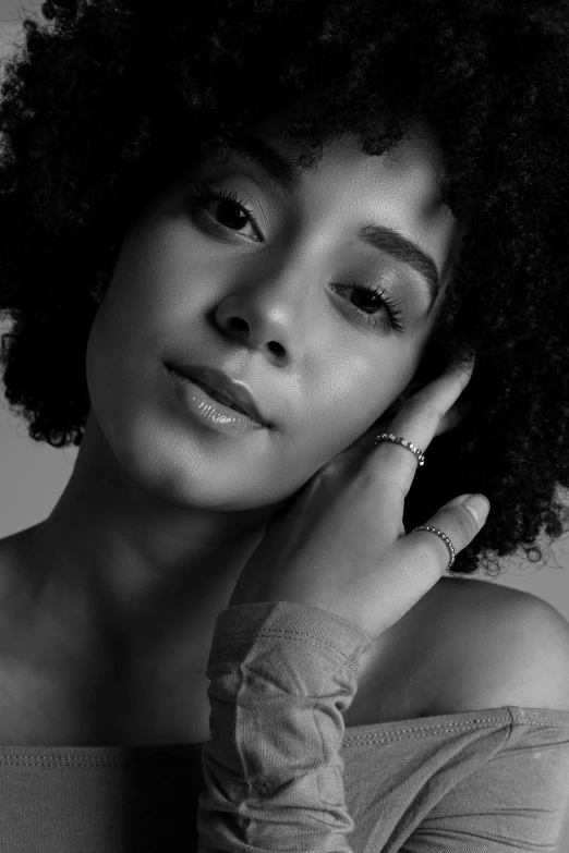 a black and white photo of a woman with an afro, by Lily Delissa Joseph, hand on her chin, a beautiful young woman, iris compiet, promo image