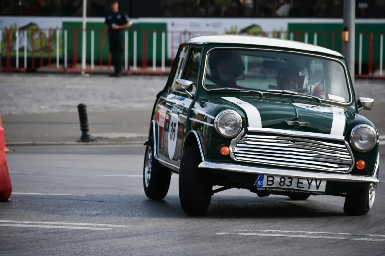 a small green and white car driving down a street, pexels contest winner, rally driving photo, mini cooper, old style, tehran