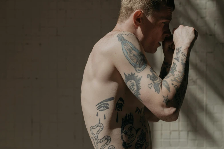 a man with a lot of tattoos on his body, inspired by Seb McKinnon, trending on pexels, bo burnham, under a shower, smooth pale skin, soft light from the side