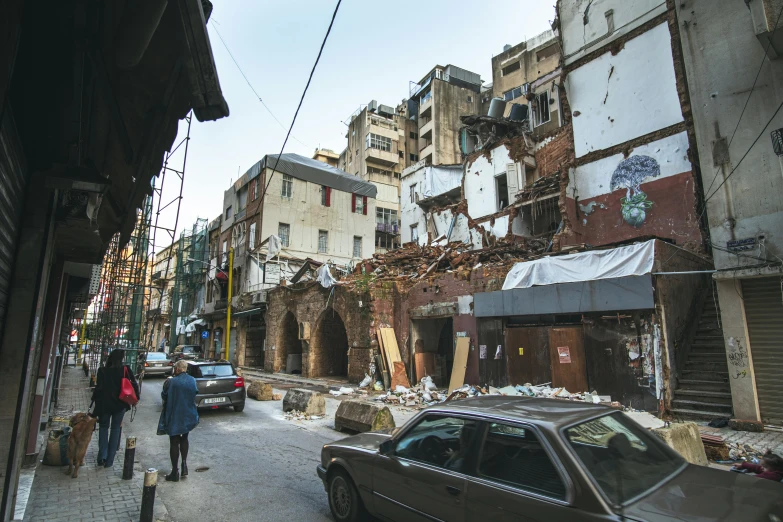 a car driving down a street next to tall buildings, a photo, byzantine ruins, debris spread, arper's bazaar, dry archways