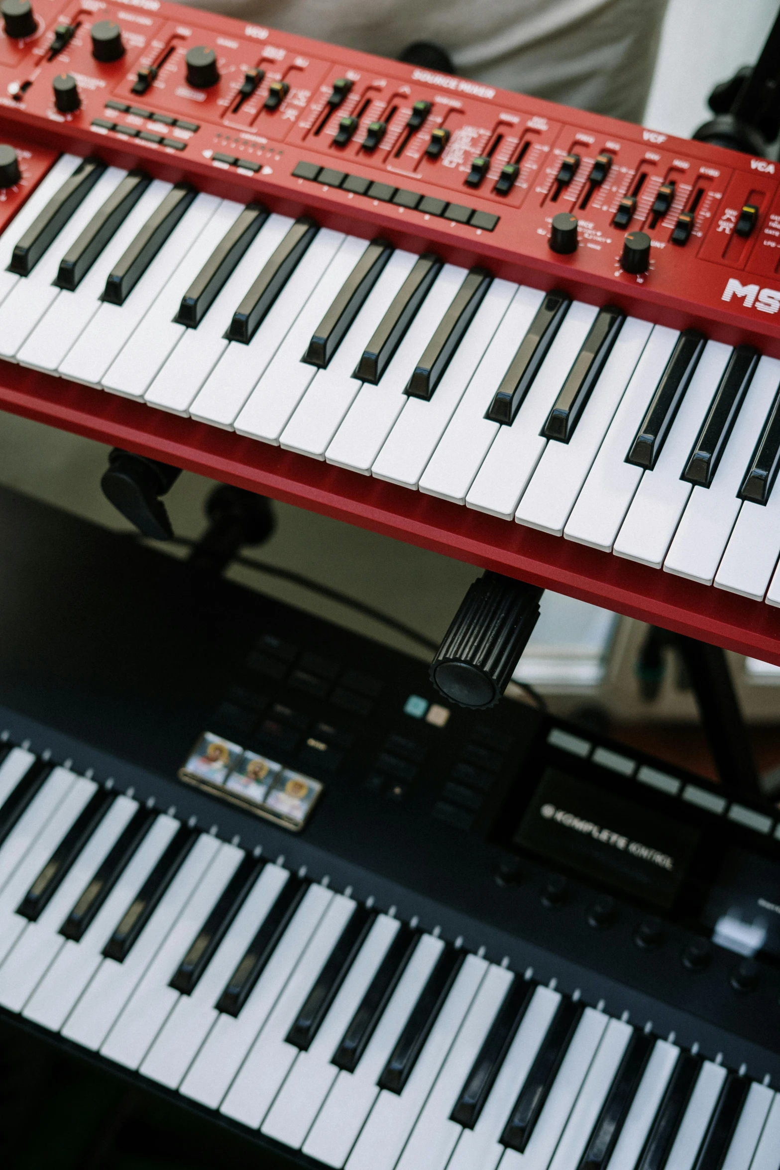 a red keyboard sitting on top of a table, synthesizers, multiple stories, product shot, instrument