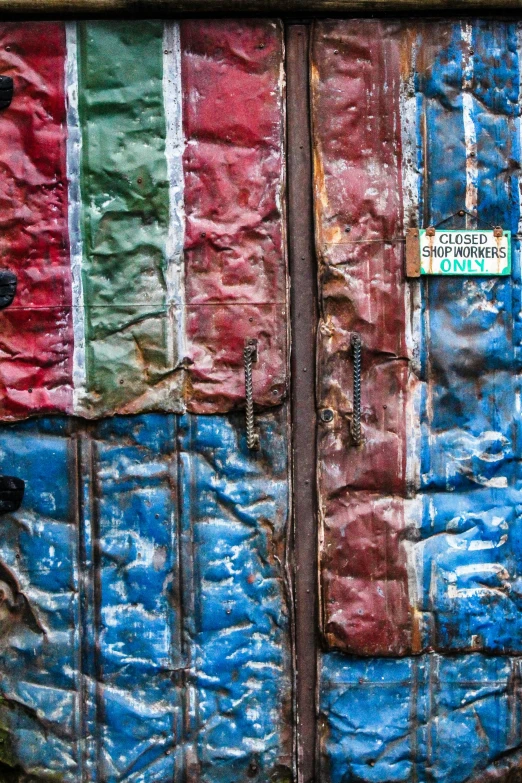 a blue fire hydrant sitting in front of a door, an album cover, inspired by Steve McCurry, graffiti, colorful torn fabric, rusty metal towers, nepal, multicolor