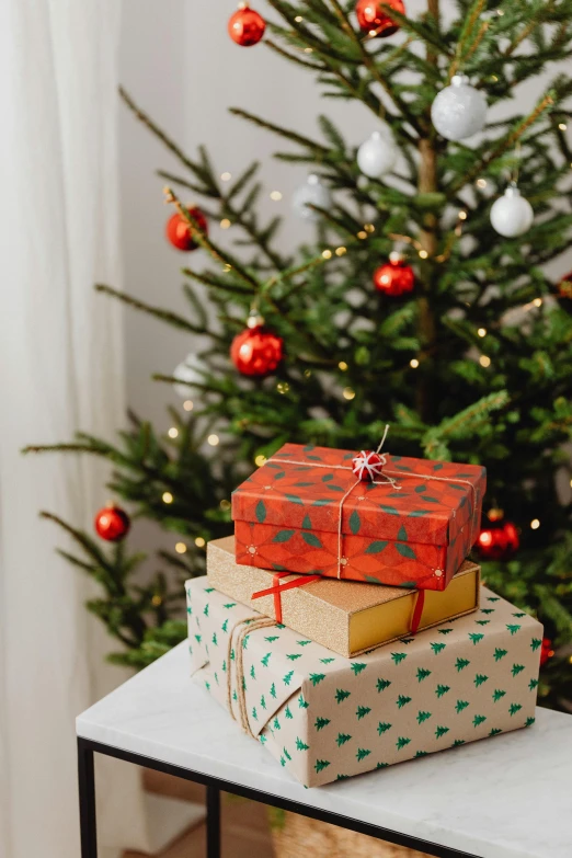 three presents stacked on top of each other in front of a christmas tree, by Julia Pishtar, zoomed out shot, overview, promo image, detailed product shot