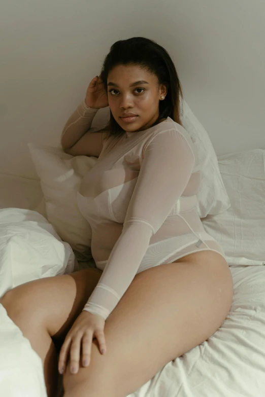 a woman sitting on top of a bed covered in white sheets, featured on reddit, renaissance, muted colored bodysuit, clear curvy details, promo image, black teenage girl