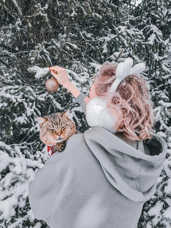 a person holding a cat in the snow, 🎀 🧟 🍓 🧚, cloudy grey hair, on a tree, profile image