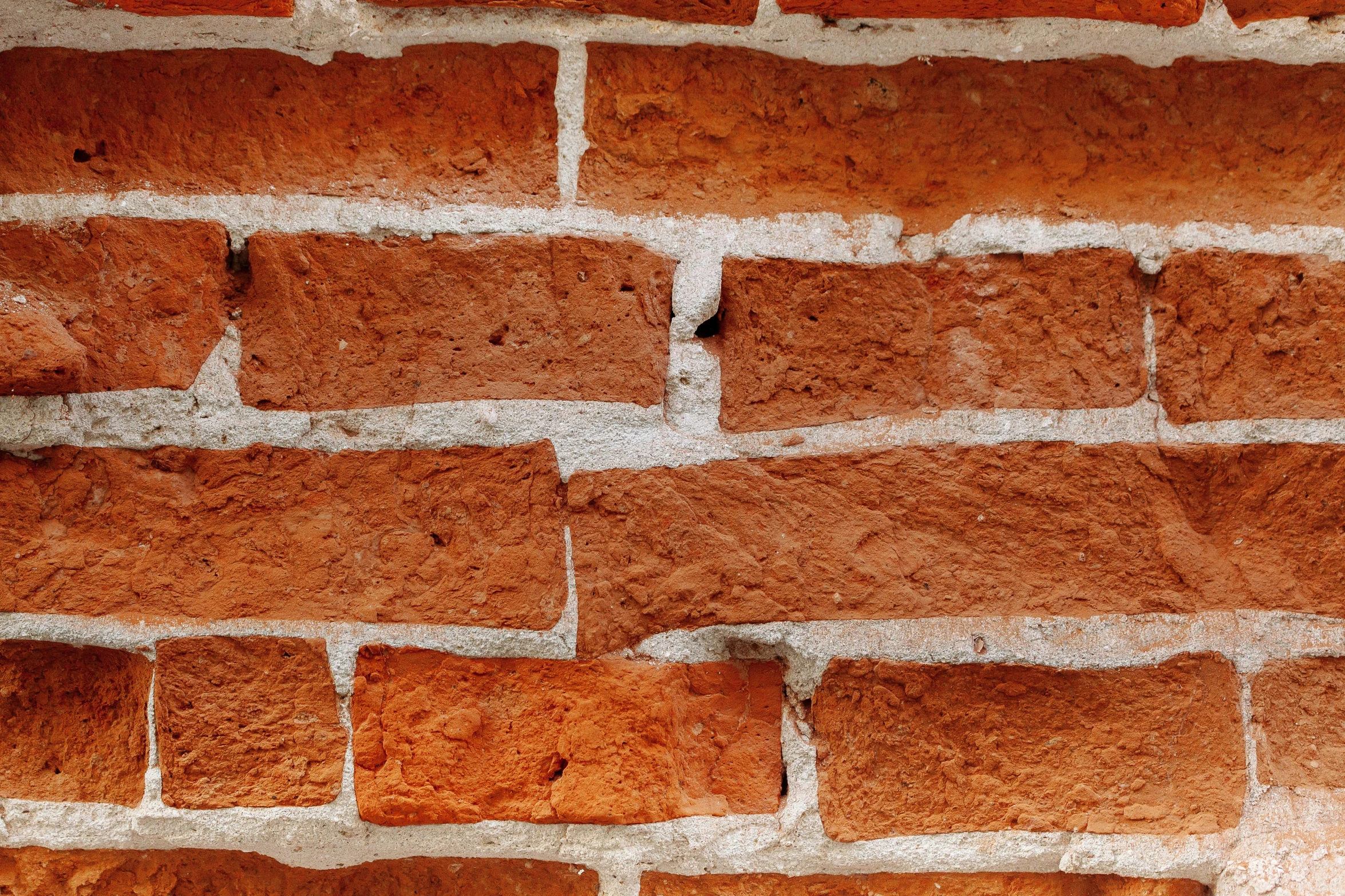 a fire hydrant in front of a brick wall, by David Simpson, unsplash, zoomed out to show entire image, brick wall texture, timbered house with bricks, closeup - view