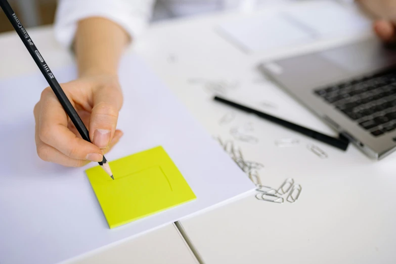 a person writing on a piece of paper with a pencil, ink on post it note, 9 9 designs, thumbnail, neon accents