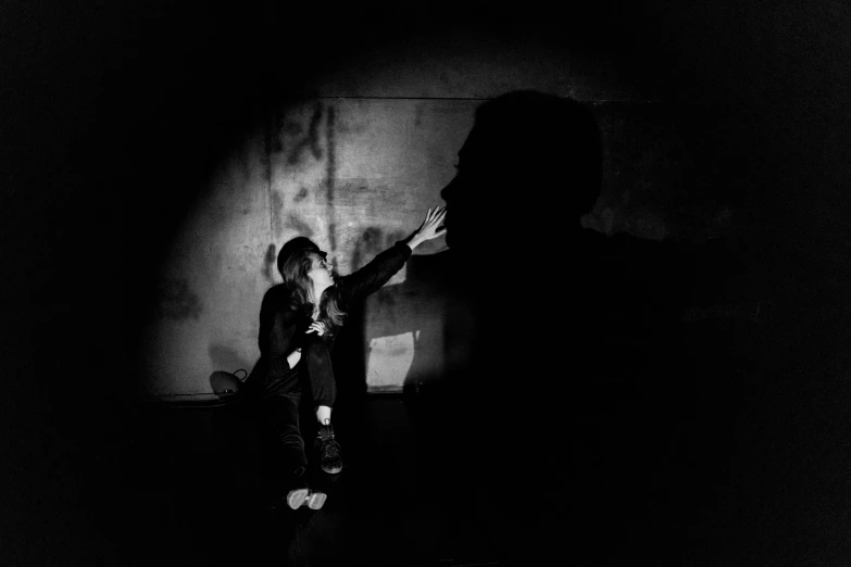 a man standing next to a woman in a dark room, a black and white photo, by Kristian Zahrtmann, conceptual art, threatening, uploaded, playing, high shadow