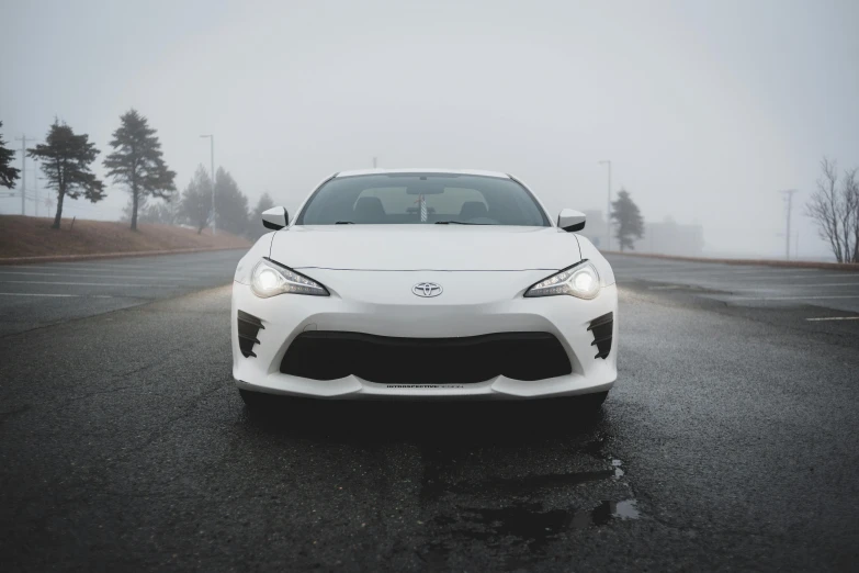 a white sports car driving on a foggy road, by Carey Morris, pexels contest winner, front face, japanese, soft top, icy