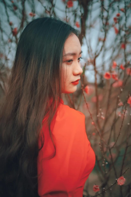 a woman with long hair standing in front of a tree, inspired by Cheng Jiasui, pexels contest winner, coral red, medium format. soft light, chinese woman, red flowers