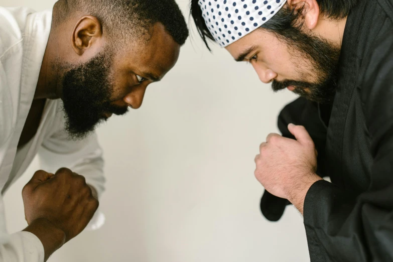 a couple of men standing next to each other, pexels contest winner, hurufiyya, getting ready to fight, black beard, praying, varying ethnicities