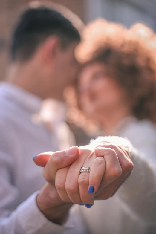 a man and a woman holding hands in front of a building, pexels contest winner, engagement ring ads, sunlit, hugging, woman